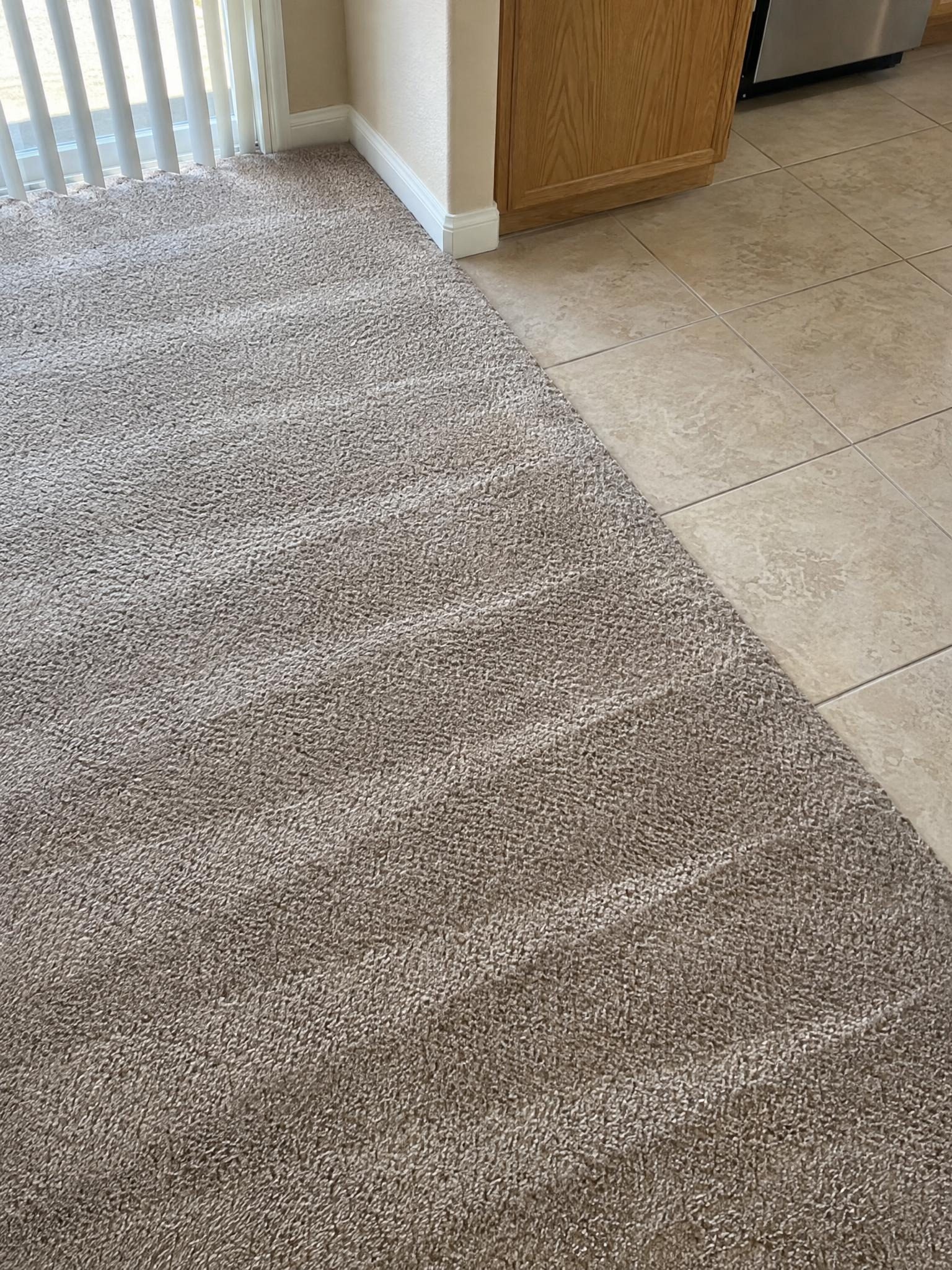After: the same carpet by the kitchen tile, clean with even wand stripes